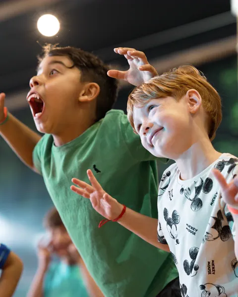 Dois meninos gritando de empolgação numa festa infantil